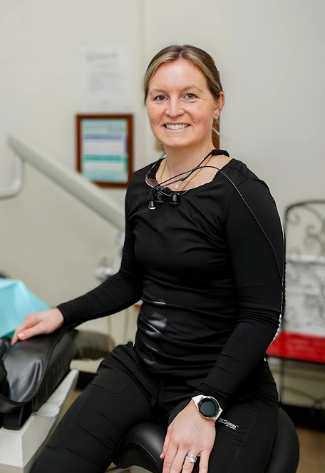 Smiling dental professional in black athletic wear at Fitchburg dental practice.
