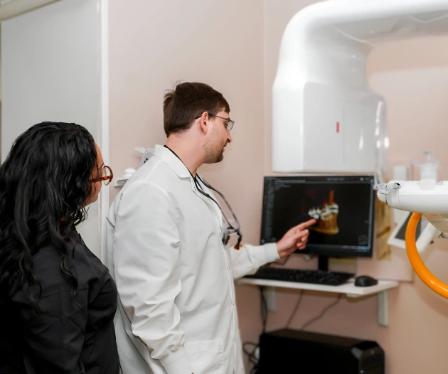 Dentist explaining digital scan results to patient in modern dental office.
