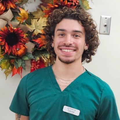 Gabriel Ramos, dental team member in teal scrubs, smiling at Fitchburg dental practice.