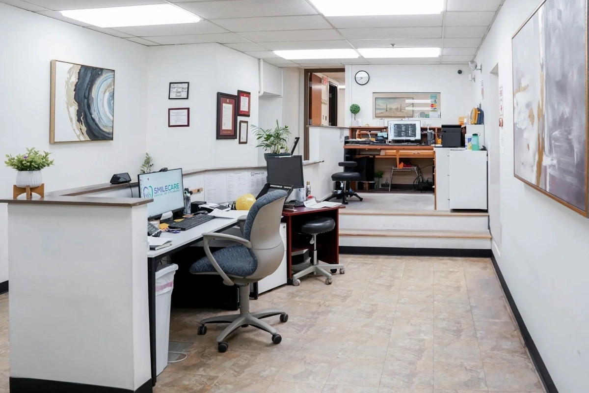 Smile Care dental office reception area with front desk, computer workstation, and professional waiting space.