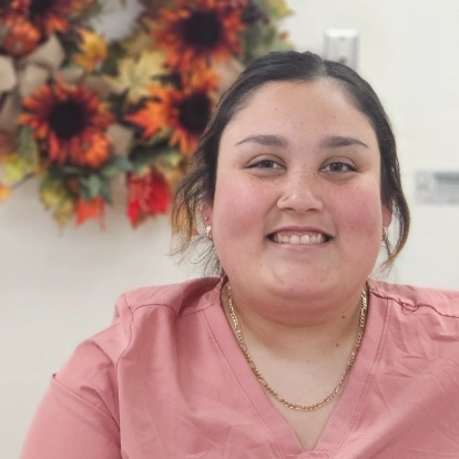 Yanailiz smiling in a pink shirt at Fitchburg dental practice.